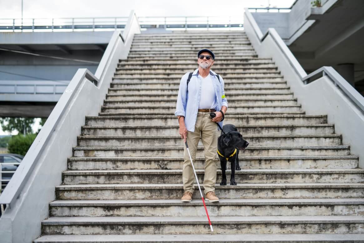 blind man with her dog going down on the stairs