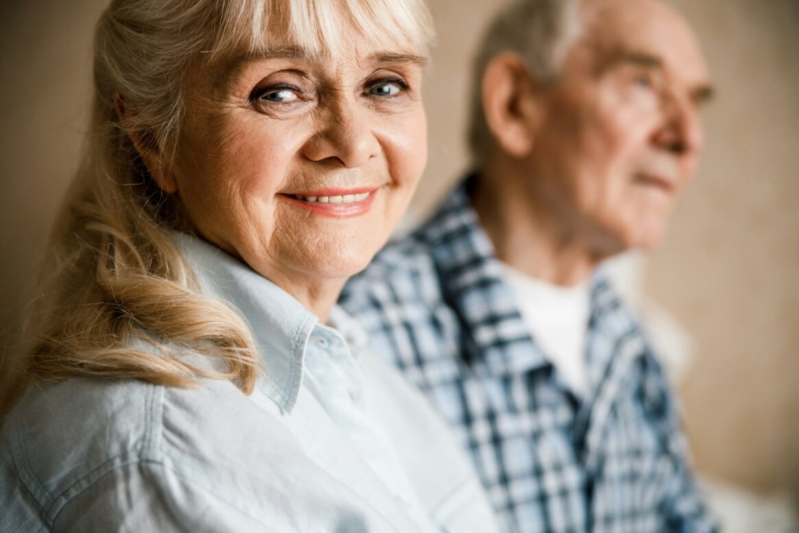 elderly woman and man smiling and thinking